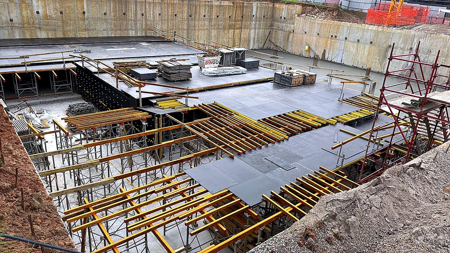 Suspended slab formwork with plywood panels, timber bearers and shoring inside an excavation.